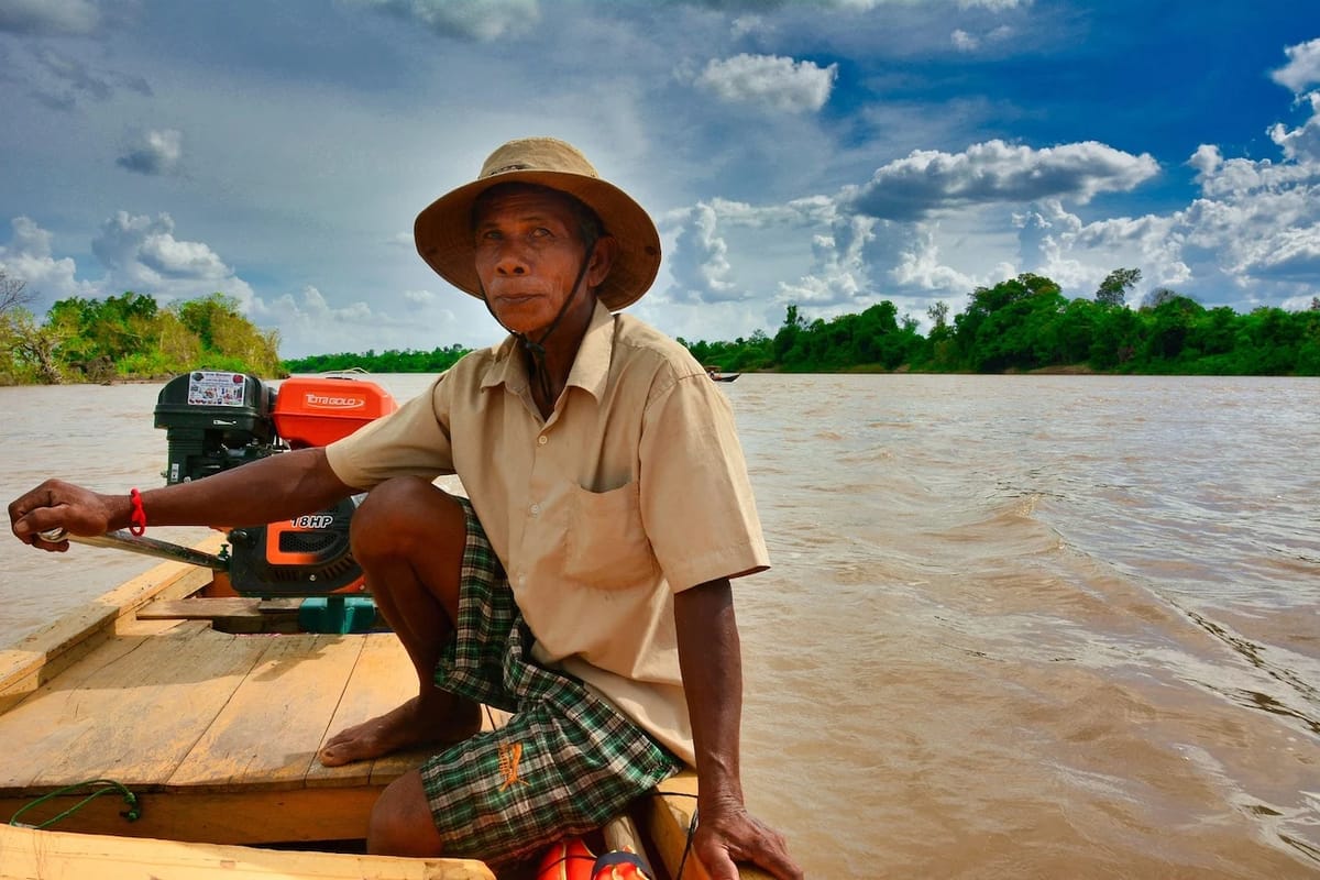 Man in hat sits on river boat