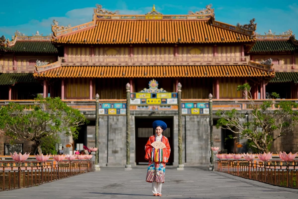 woman in traditional costume near yellow red building