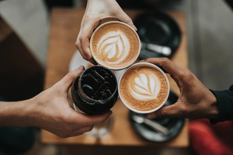two people holding coffee cups wooden table setting