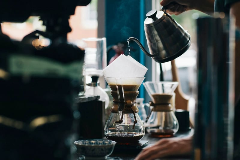Coffee being poured into a glass at a cafe